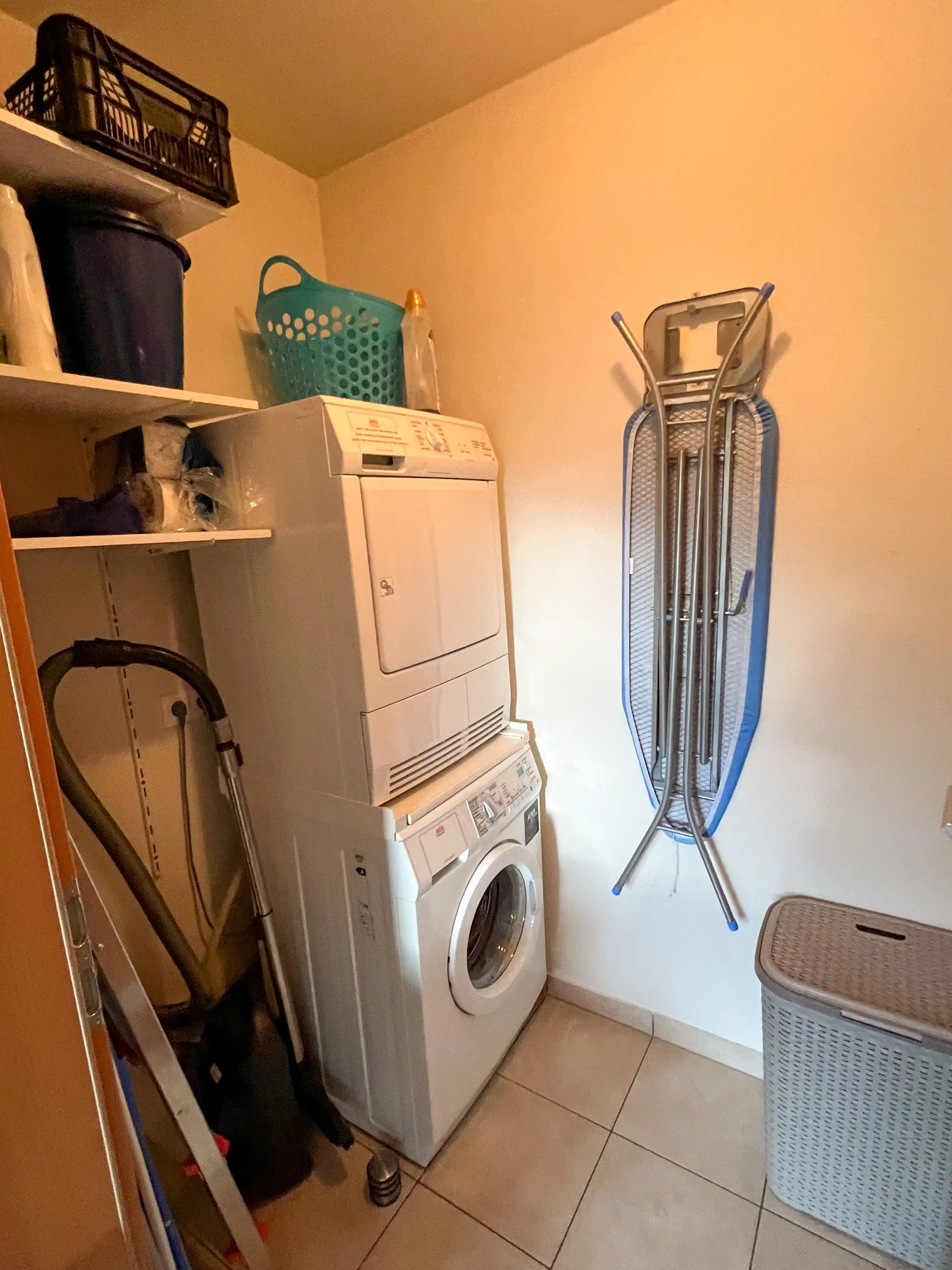 Voorzieningen in de bijkeuken met wasmachine, wasdroger en voorraadkast
